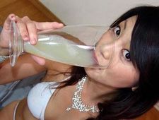Asian is drinking a large glass of cum.